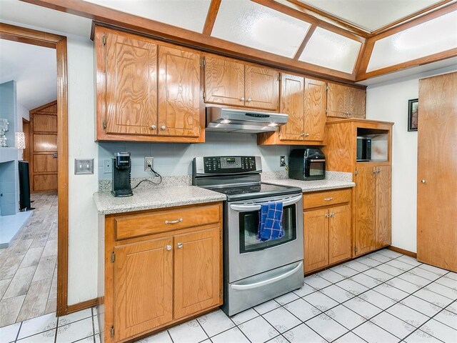 17612 Durbin Park Rd, Edmond, OK 73012 - kitchen featuring under cabinet range hood, stainless steel electric range, light countertops, and brown cabinetry