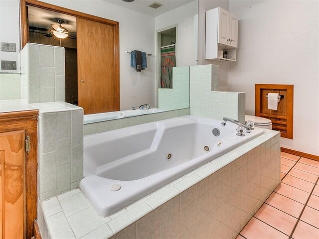 17612 Durbin Park Rd, Edmond, OK 73012 - full bathroom featuring a tub with jets, tile patterned flooring, toilet, ceiling fan, and baseboards