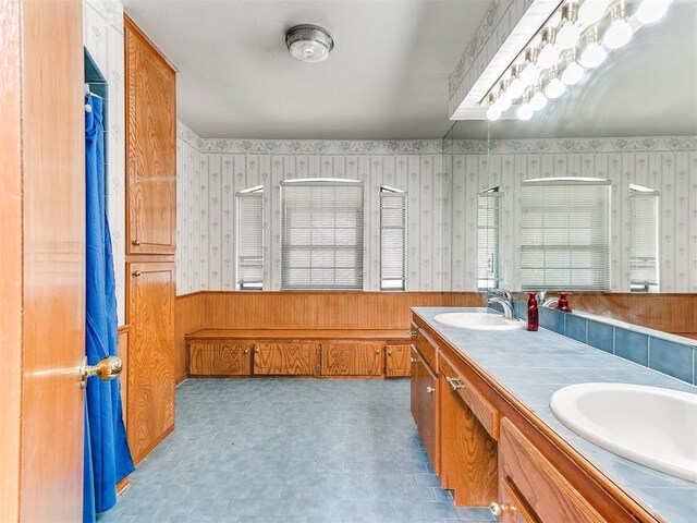 17612 Durbin Park Rd, Edmond, OK 73012 - full bathroom featuring wallpapered walls, a wainscoted wall, double vanity, a shower, and tile patterned floors