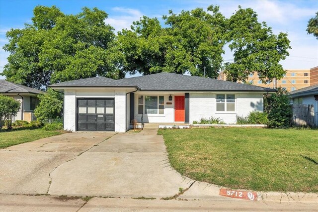5712 N Roff Ave, Oklahoma City, OK 73112 - view of front facade featuring an attached garage, brick siding, and concrete driveway