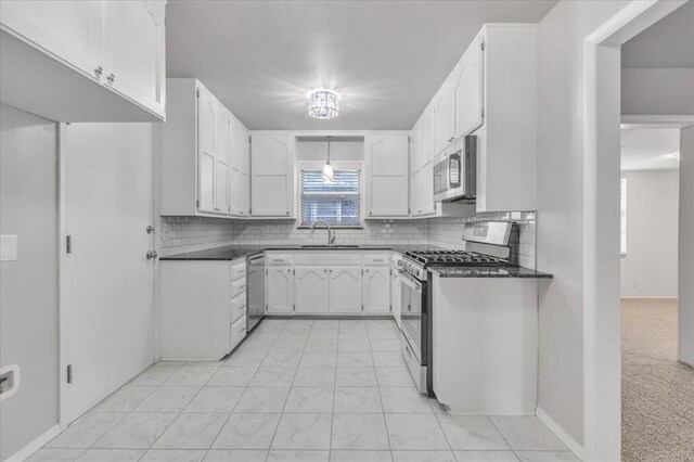 5712 N Roff Ave, Oklahoma City, OK 73112 - kitchen featuring appliances with stainless steel finishes, dark countertops, a sink, backsplash, and light marble finish floors