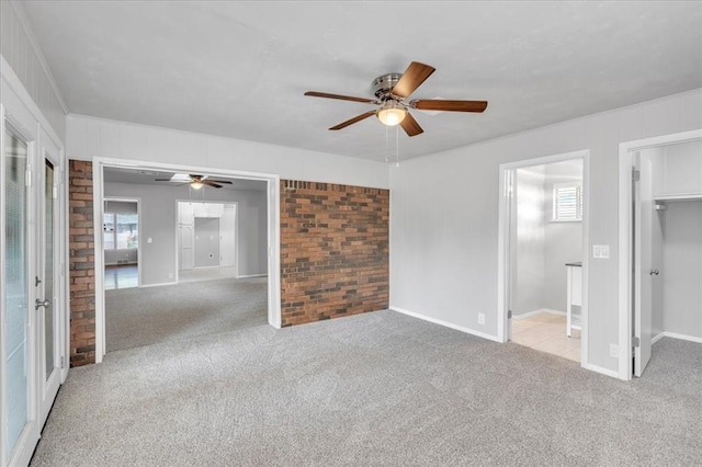 5712 N Roff Ave, Oklahoma City, OK 73112 - unfurnished bedroom featuring carpet, a walk in closet, multiple windows, and brick wall