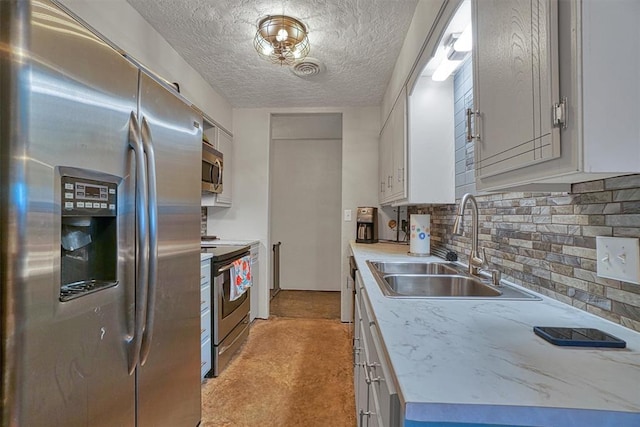 1301 Canterbury Blvd, Altus, OK 73521 - kitchen with appliances with stainless steel finishes, a sink, backsplash, light countertops, and a textured ceiling