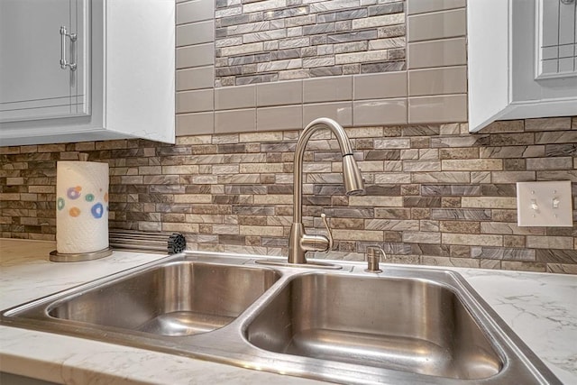 1301 Canterbury Blvd, Altus, OK 73521 - kitchen view of a sink, backsplash, and white cabinets