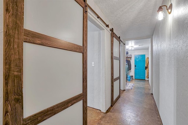 1301 Canterbury Blvd, Altus, OK 73521 - corridor featuring a barn door, finished concrete flooring, a textured ceiling, and a textured wall
