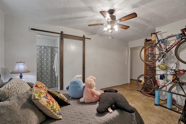 1301 Canterbury Blvd, Altus, OK 73521 - bedroom with a barn door, finished concrete floors, a textured ceiling, and a ceiling fan