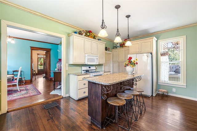 516 S Macomb Ave, El Reno, OK 73036 - kitchen featuring white appliances, crown molding, dark wood-type flooring, a kitchen breakfast bar, and pendant lighting