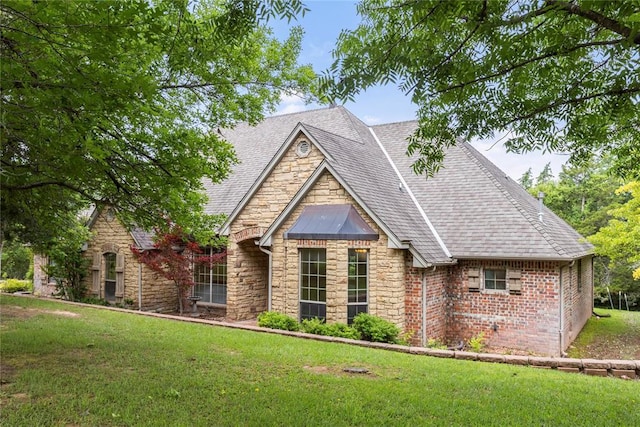 6373 Stone Valley Dr, Edmond, OK 73034 - view of front facade with stone siding, a front yard, and a shingled roof