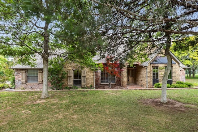 6373 Stone Valley Dr, Edmond, OK 73034 - view of property hidden behind natural elements with stone siding and a front lawn