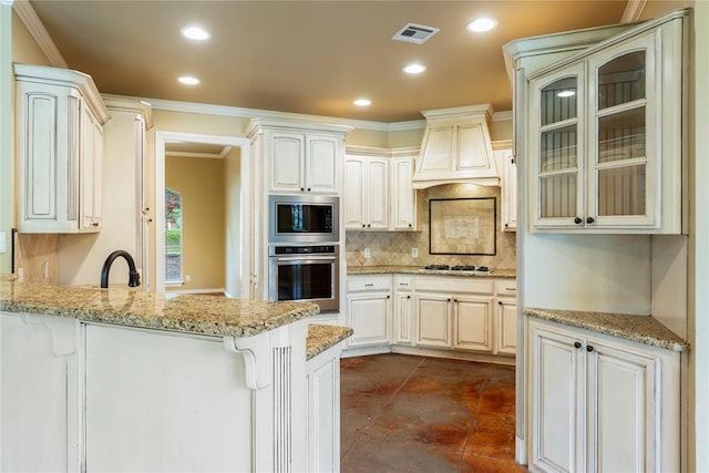 6373 Stone Valley Dr, Edmond, OK 73034 - kitchen featuring appliances with stainless steel finishes, a peninsula, crown molding, tasteful backsplash, and glass insert cabinets