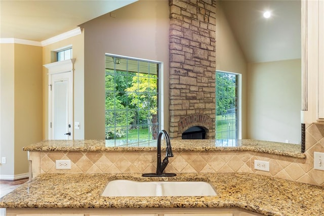 6373 Stone Valley Dr, Edmond, OK 73034 - kitchen with a sink, healthy amount of natural light, tasteful backsplash, light stone countertops, and crown molding