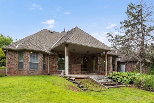 6373 Stone Valley Dr, Edmond, OK 73034 - rear view of house with brick siding, a yard, and roof with shingles