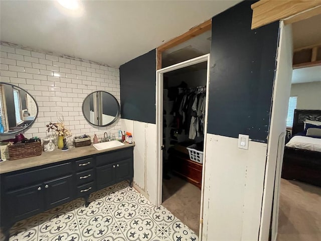 513 E Monroe St, Maud, OK 74854 - ensuite bathroom with vanity, a walk in closet, and tile patterned floors