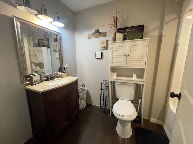 513 E Monroe St, Maud, OK 74854 - bathroom featuring toilet, vanity, wood finished floors, and baseboards