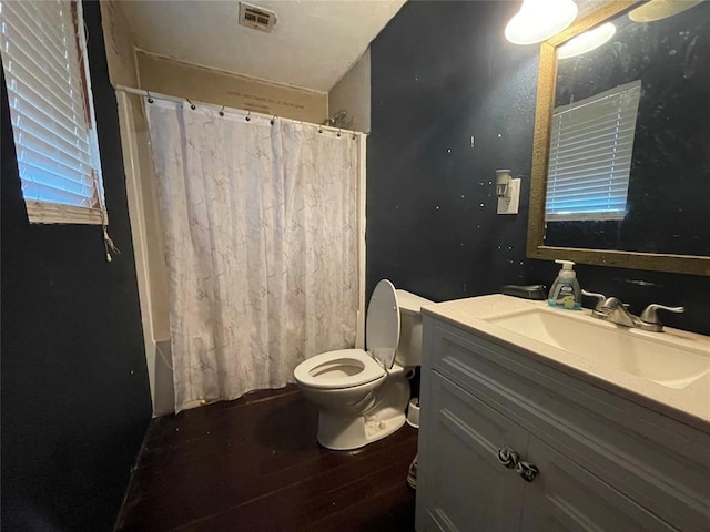 513 E Monroe St, Maud, OK 74854 - full bath featuring toilet, vanity, wood finished floors, and shower / tub combo with curtain