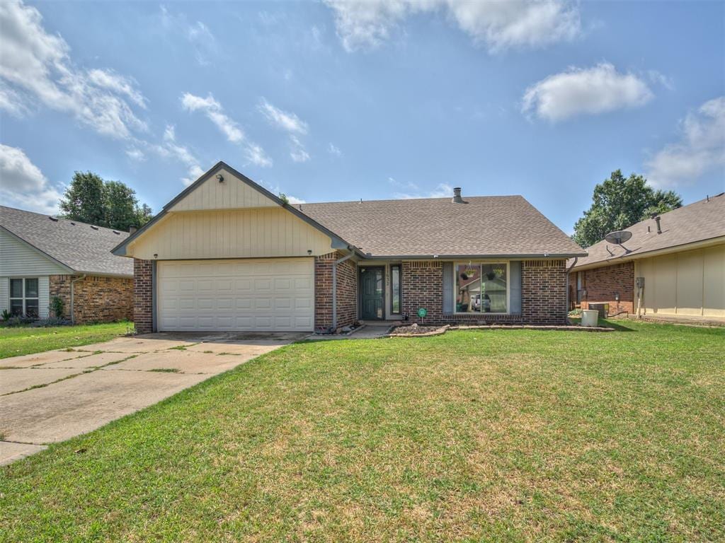 11632 SW 3rd Ter, Yukon, OK 73099 - view of front of property with a garage, concrete driveway, a front lawn, brick siding, and central AC unit
