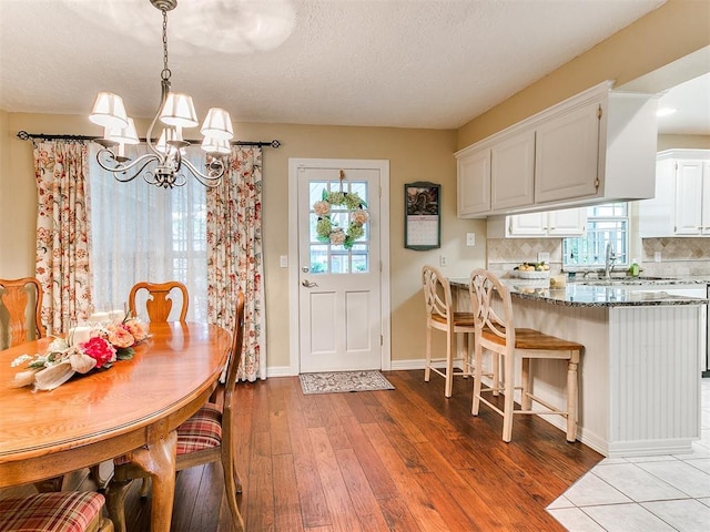 1513 E Main St, Moore, OK 73160 - dining room with a chandelier, wood finished floors, baseboards, and a textured ceiling