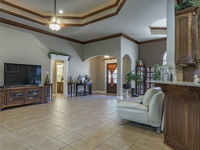 421 Meadow Run Ct, Yukon, OK 73099 - living area featuring a tray ceiling, arched walkways, ornamental molding, light tile patterned flooring, and ceiling fan