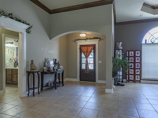 421 Meadow Run Ct, Yukon, OK 73099 - entryway with crown molding, arched walkways, baseboards, and light tile patterned floors