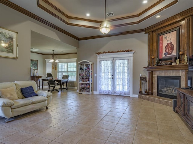 421 Meadow Run Ct, Yukon, OK 73099 - living room featuring a raised ceiling, ornamental molding, light tile patterned floors, a tiled fireplace, and baseboards