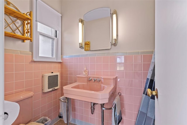 1616 SW 6th Ave, Ardmore, OK 73401 - bathroom featuring tile walls, toilet, wainscoting, heating unit, and a sink