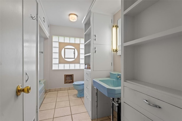 1616 SW 6th Ave, Ardmore, OK 73401 - full bath featuring toilet, tile patterned floors, a sink, shower / washtub combination, and baseboards
