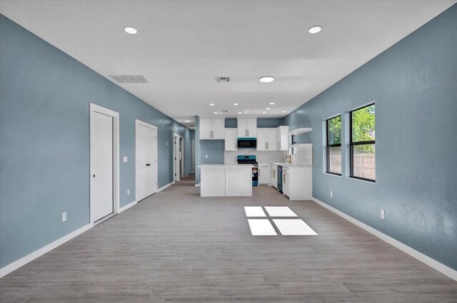 1435 NE 27th St, Oklahoma City, OK 73111 - unfurnished living room with light wood-type flooring, baseboards, and recessed lighting