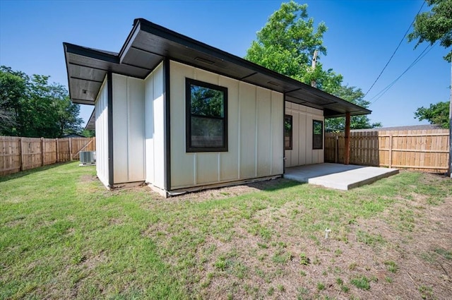 1435 NE 27th St, Oklahoma City, OK 73111 - back of property with a patio, central AC unit, and board and batten siding