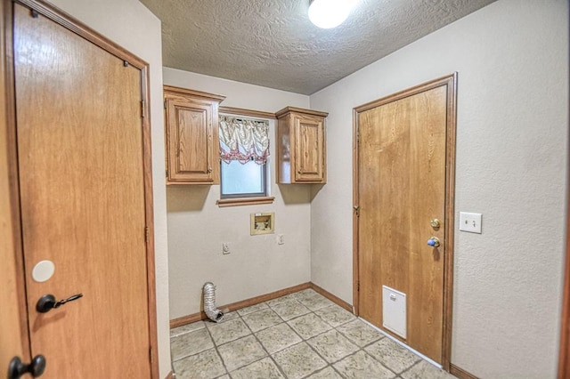 3100 Windward Ct, Norman, OK 73072 - laundry room featuring baseboards, a textured ceiling, hookup for a washing machine, cabinet space, and light tile patterned floors