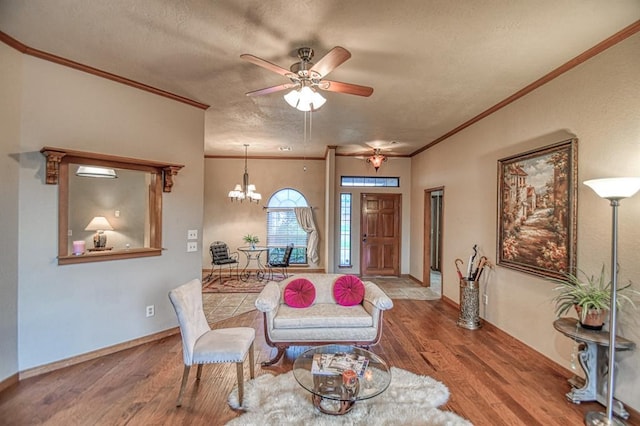 3100 Windward Ct, Norman, OK 73072 - living room featuring wood finished floors, crown molding, a textured ceiling, ceiling fan, and a chandelier