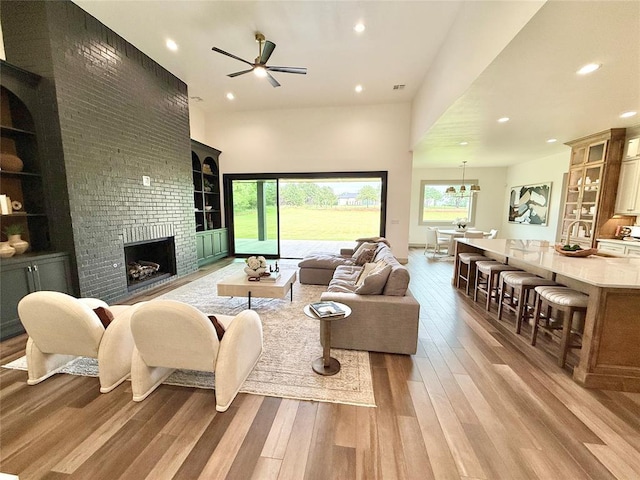 3320 Somerset Farms Rd, Newalla, OK 74857 - living area with light wood-style flooring, a ceiling fan, a brick fireplace, recessed lighting, and built in features