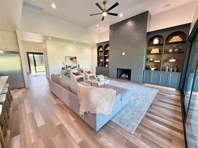 3320 Somerset Farms Rd, Newalla, OK 74857 - living room featuring built in shelves, a brick fireplace, ceiling fan, light wood-style floors, and recessed lighting