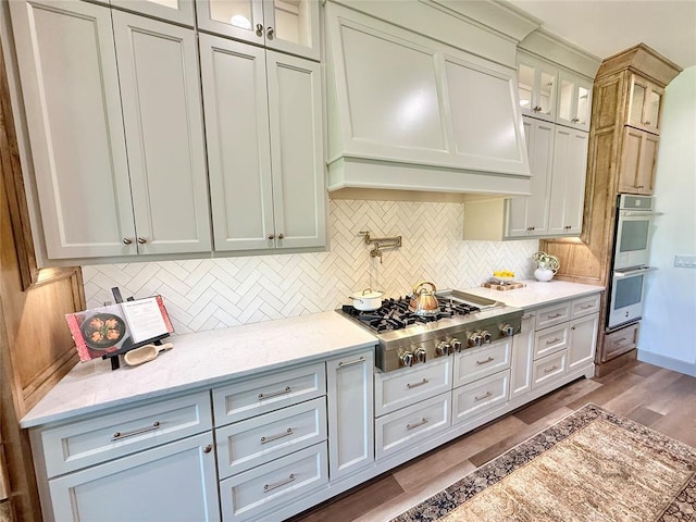 3320 Somerset Farms Rd, Newalla, OK 74857 - kitchen with stainless steel appliances, wood finished floors, glass insert cabinets, and tasteful backsplash