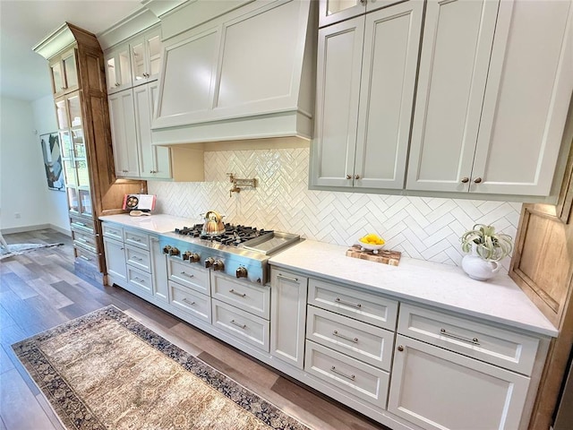 3320 Somerset Farms Rd, Newalla, OK 74857 - kitchen with custom range hood, stainless steel gas cooktop, backsplash, glass insert cabinets, and dark wood finished floors