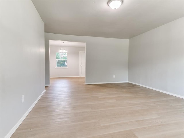 3522 SW 39th St, Oklahoma City, OK 73119 - empty room featuring baseboards, light wood finished floors, and a chandelier