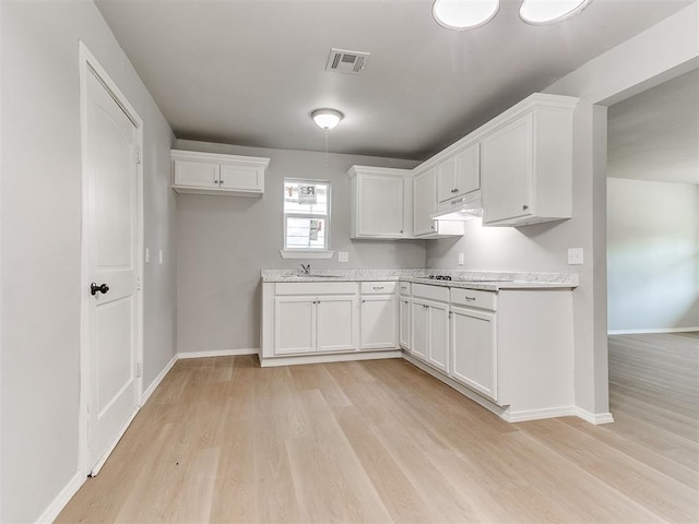 3522 SW 39th St, Oklahoma City, OK 73119 - kitchen with light wood-style floors, white cabinets, and light countertops