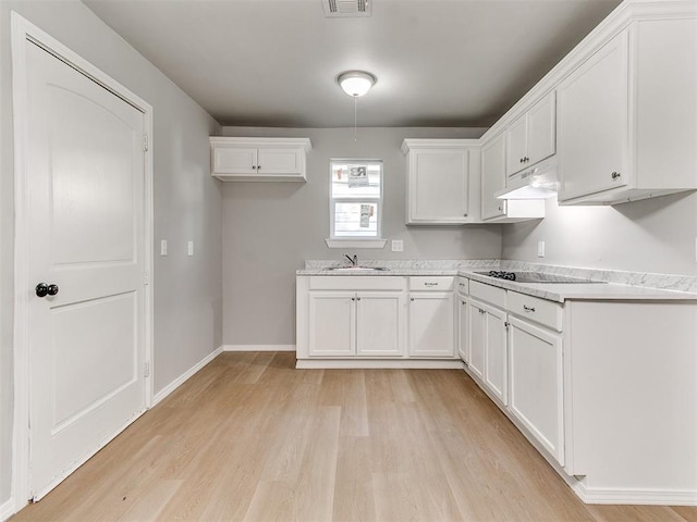3522 SW 39th St, Oklahoma City, OK 73119 - kitchen featuring light wood finished floors, a sink, white cabinetry, and light countertops