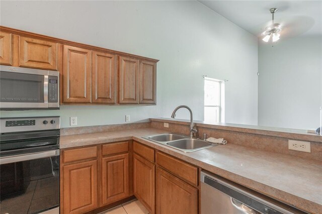 1217 SW 18th St, Oklahoma City, OK 73109 - kitchen featuring appliances with stainless steel finishes, a sink, brown cabinets, and light countertops
