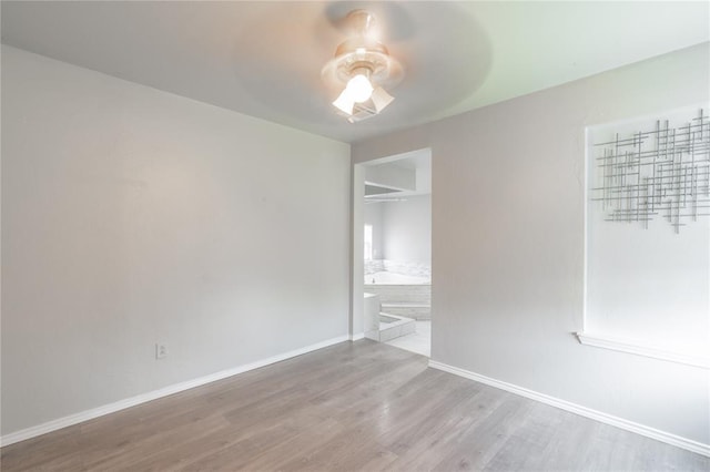 1217 SW 18th St, Oklahoma City, OK 73109 - unfurnished bedroom featuring wood finished floors, baseboards, a ceiling fan, and ensuite bathroom