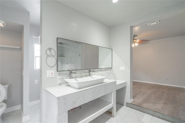 1217 SW 18th St, Oklahoma City, OK 73109 - bathroom with toilet, a ceiling fan, marble finish floors, vanity, and baseboards