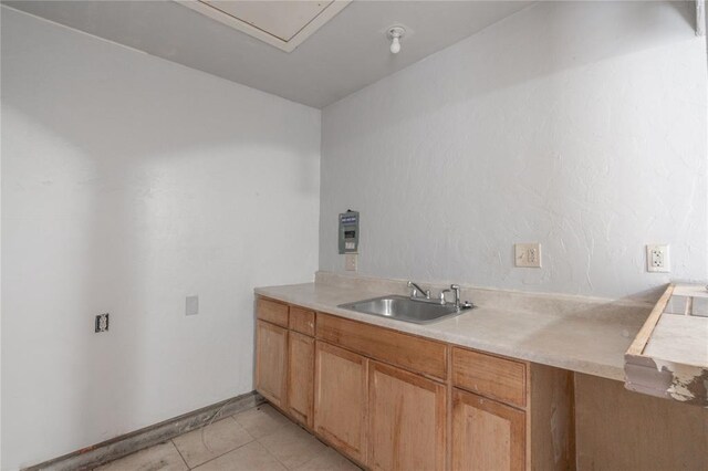 1217 SW 18th St, Oklahoma City, OK 73109 - kitchen featuring a sink, light countertops, light tile patterned floors, and brown cabinets