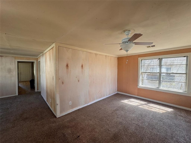 424 Jefferson St, Seminole, OK 74868 - carpeted spare room with a ceiling fan, baseboards, and wooden walls