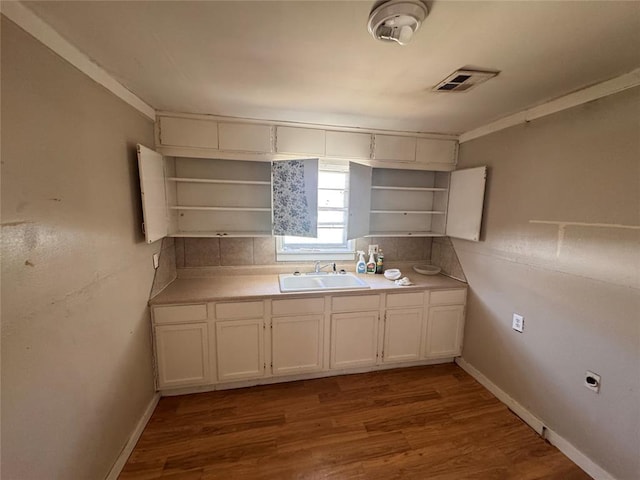 424 Jefferson St, Seminole, OK 74868 - kitchen with open shelves, a sink, and wood finished floors