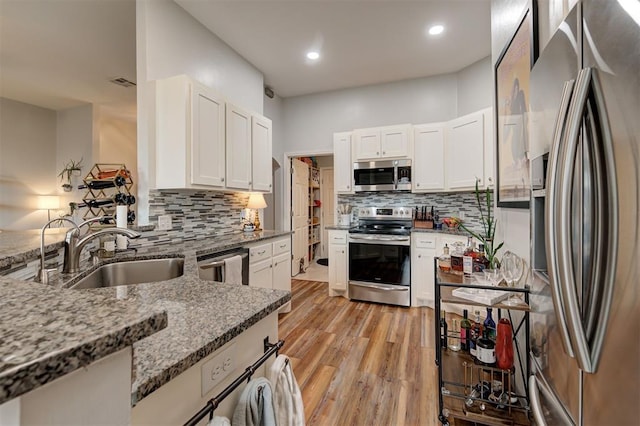 4236 Notting Hill Dr, Moore, OK 73160 - kitchen featuring appliances with stainless steel finishes, a sink, light stone counters, decorative backsplash, and recessed lighting