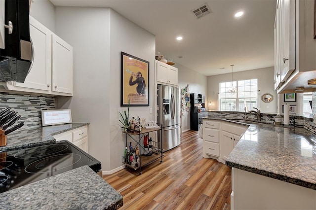 4236 Notting Hill Dr, Moore, OK 73160 - kitchen with stainless steel refrigerator with ice dispenser, a peninsula, a sink, decorative backsplash, and recessed lighting