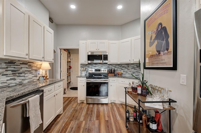 4236 Notting Hill Dr, Moore, OK 73160 - kitchen with stainless steel appliances, decorative backsplash, white cabinets, light wood-style floors, and recessed lighting