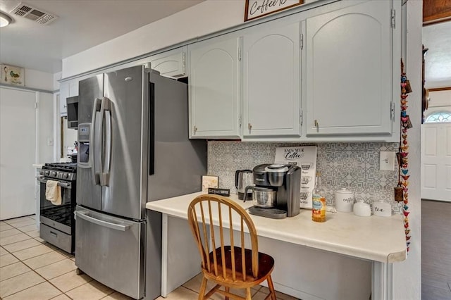 912 SW 4th Pl, Moore, OK 73160 - kitchen with stainless steel appliances, light countertops, decorative backsplash, and light tile patterned flooring