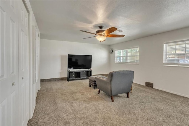 912 SW 4th Pl, Moore, OK 73160 - living room featuring carpet floors, ceiling fan, baseboards, and a textured ceiling