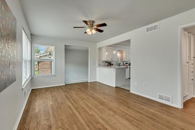 615 Ridgecrest Rd, Edmond, OK 73013 - unfurnished living room with a ceiling fan, baseboards, and light wood-style flooring