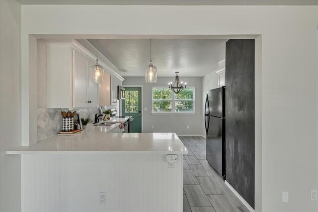 615 Ridgecrest Rd, Edmond, OK 73013 - kitchen with freestanding refrigerator, light countertops, a sink, tasteful backsplash, and white cabinetry